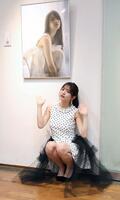 お気に入りの写真を前にポーズをとる黒嵜菜々子