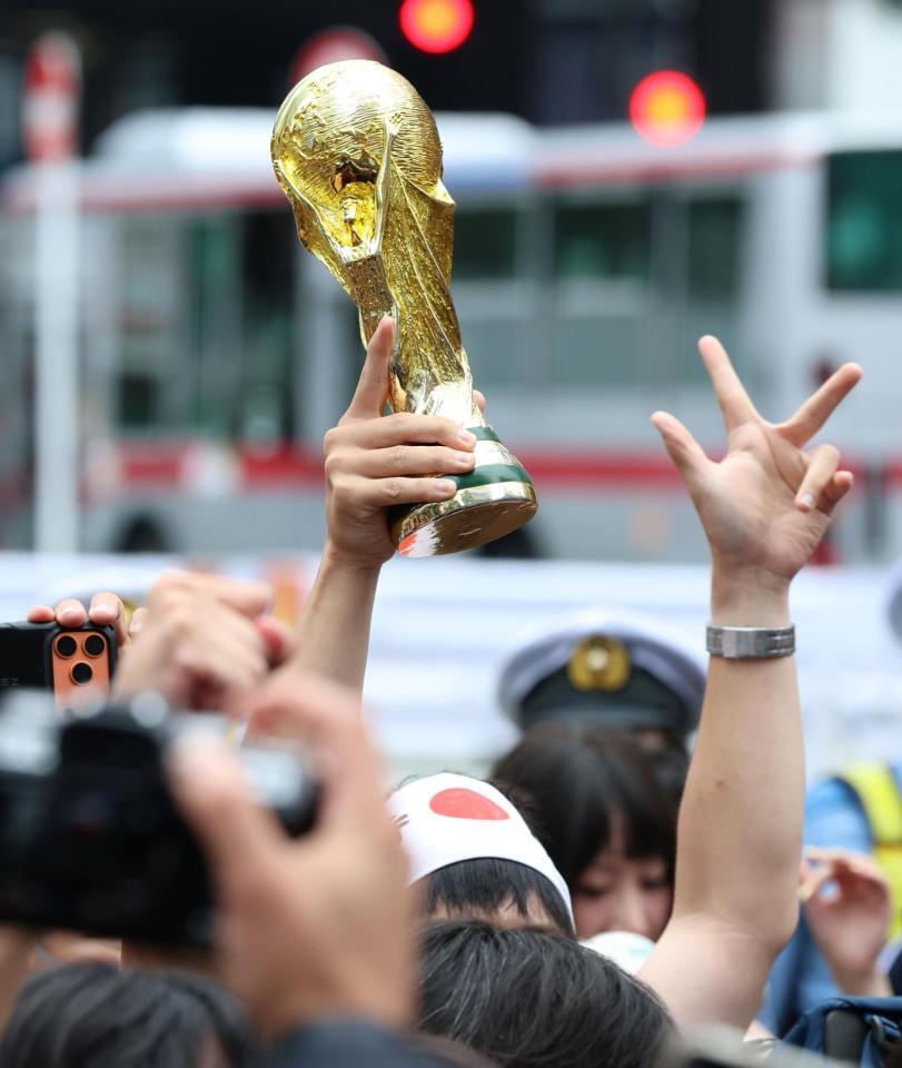 日本が１次Ｌ突破を決め、路上で掲げられた優勝トロフィーのレプリカ（撮影・伊藤笙子）