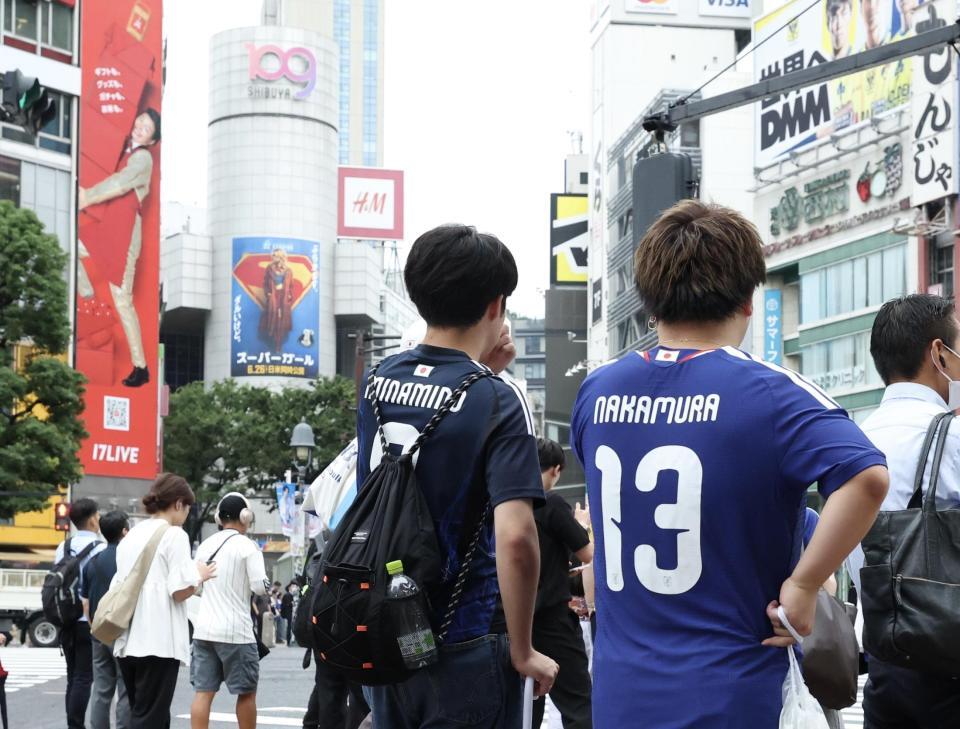 スクランブル交差点で信号待ちをするサッカー日本代表ユニフォームを着たサポーター（撮影・伊藤笙子）