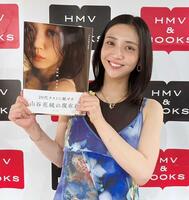 　写真集を手に笑顔の山谷花純