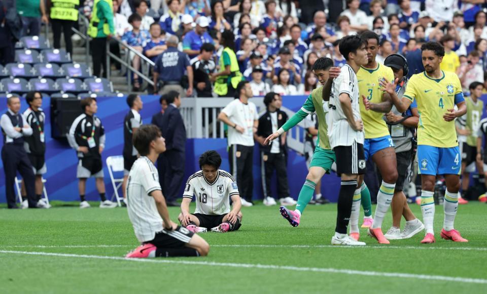 ブラジルに敗れピッチに座り込む日本代表・上田綺世（奥）。右では冨安健洋がブラジルの選手たちから声をかけられる＝６月２９日、ヒューストン