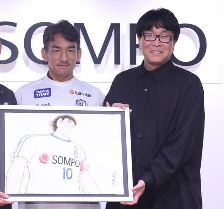 キービジュアルを手にする中田英寿氏（左）と高橋陽一氏（撮影・佐々木彰尚）