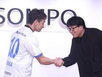 高橋陽一氏（右）と握手をする中田英寿氏（撮影・佐々木彰尚）
