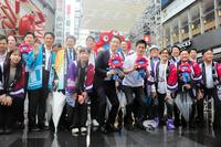 道頓堀商店街に設置されたミャクミャクモニュメント前で写真撮影する大阪市の横山英幸市長（前列中央）と大阪府の吉村洋文知事（右）