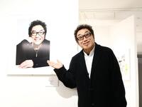 山岸伸　写真展「ＫＡＯ－日本の顔－」で自身の写真を前に変顔で撮影に応じるコロッケ