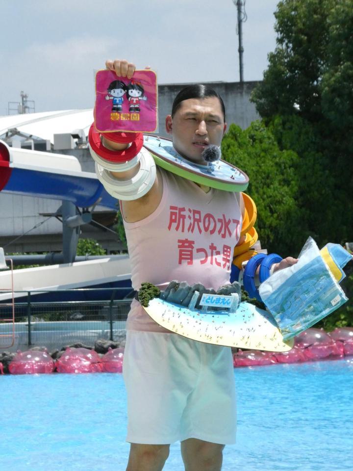 プールサイドに登場し、自慢のグッズを見せる春日俊彰