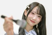 （写真説明）油絵の筆を手に笑顔の橋本真希