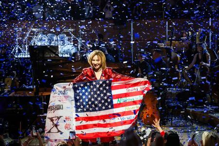 ファンからもらったアメリカ国旗を手に笑顔を浮かべるＹＯＳＨＩＫＩ