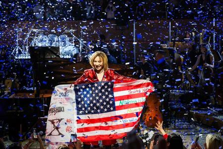 ファンからもらったアメリカ国旗を手に笑顔を浮かべるＹＯＳＨＩＫＩ