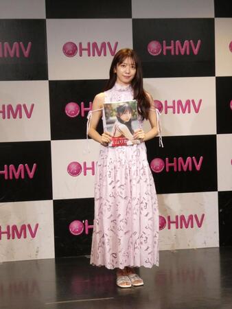 写真集を持ち撮影に応じる真山りか