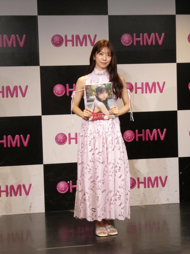 写真集を持ち撮影に応じる真山りか