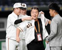 ２０１９年８月、巨人・原辰徳監督（当時）にユニホームを着せてもらう小杉竜一＝東京ドーム