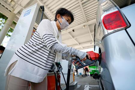 熊本県八代市のガソリンスタンドで給油する女性