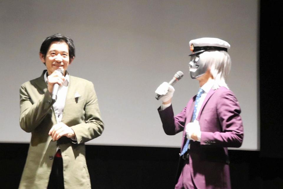 映画「怪奇タクシー　布告を知らぬ者達に」の舞台あいさつで、ストーリーテラーの怪木焚朗こと映画プロデューサー・岩田将克氏（右）と話す永山竜弥＝大阪市内