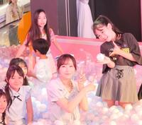 ボールプールに１つだけ隠された自身のサイン入りボールを見つけた小学生と写真に収まる真中まな（中央）