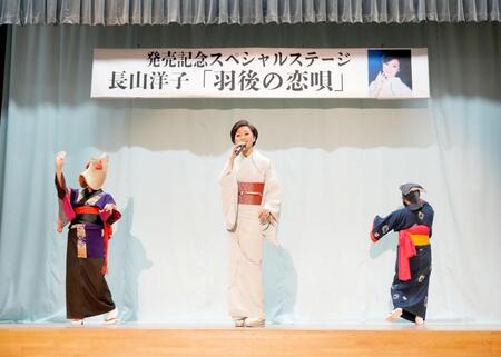 最新曲の舞台で歌声を響かせる長山洋子（中央）