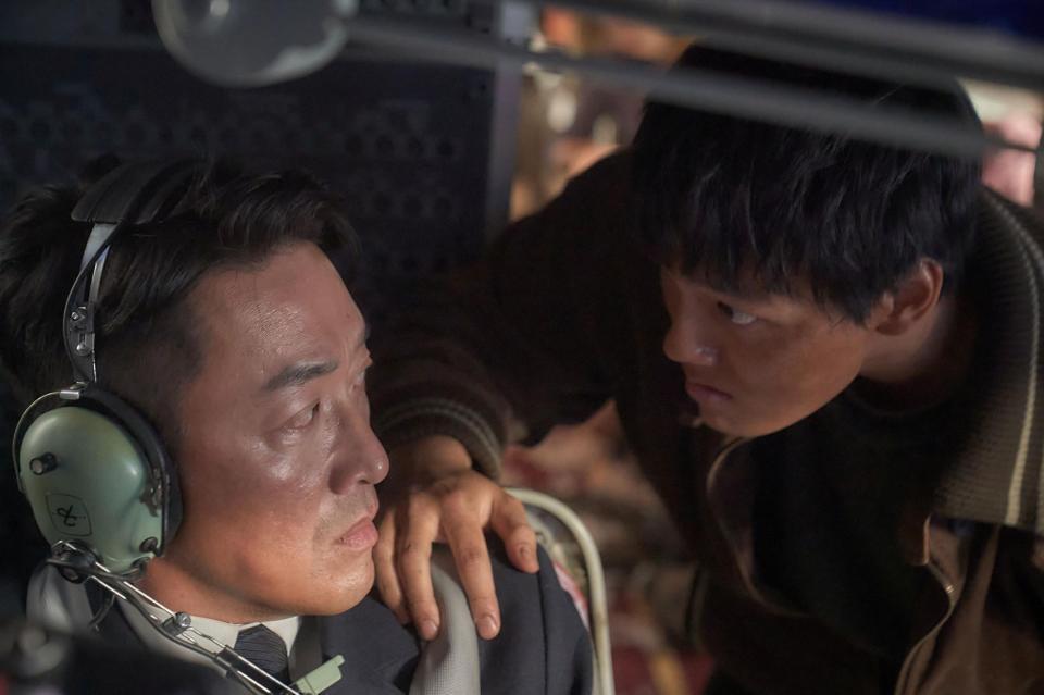 韓国映画「１９７１、ハイジャック事件」副操縦士テイン（ハ・ジョンウ）（左）に迫るハイジャック犯のヨンデ（ヨ・ジング）©　２０２４　ＫＩＤＡＲＩＳＴＵＤＩＯ，　ＩＮＣ．，　ＳＯＮＹ　ＰＩＣＴＵＲＥＳ　ＥＮＴＥＲＴＡＩＮＭＥＮＴ　ＫＯＲＥＡ　ＩＮＣ．　（ＢＲＡＮＣＨ），　ＰＥＲＦＥＣＴ　ＳＴＯＲＭ　ＦＩＬＭ　ＩＮＣ．，　ＣＨＡＮＮＥＬ　ＰＬＵＳ　ＩＮＣ．　ＡＬＬ　ＲＩＧＨＴ　ＲＥＳＥＲＶＥＤ．