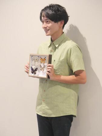 チョウの標本を手に撮影に応じた牧田習＝東京・オスカープロモーション本社