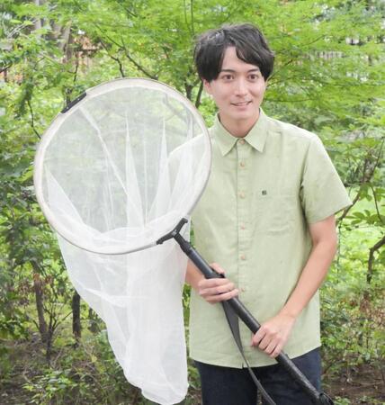 虫網片手に撮影に応じた牧田習＝東京・オスカープロモーション本社前