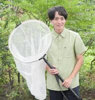 虫網片手に撮影に応じた牧田習＝東京・オスカープロモーション本社前