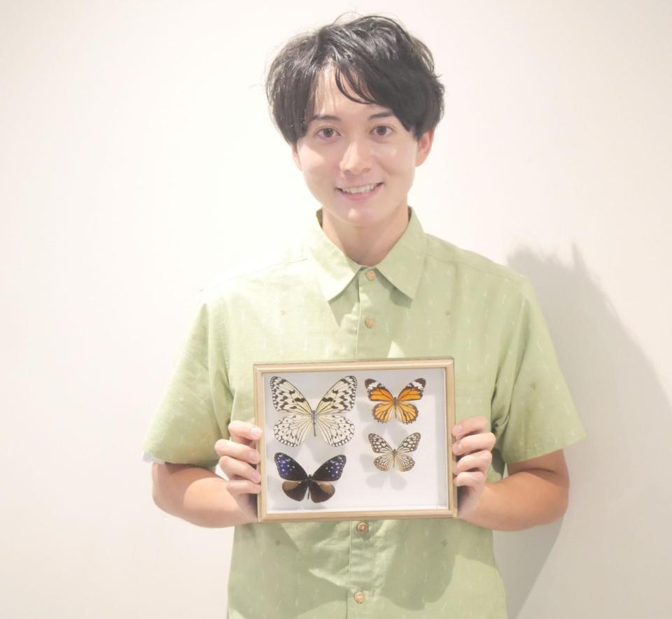 チョウの標本を手に撮影に応じた牧田習＝東京・オスカープロモーション本社
