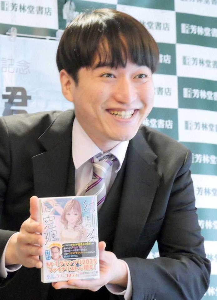 不気味な程の満面の笑みで著書をアピールする吉野おいなり君