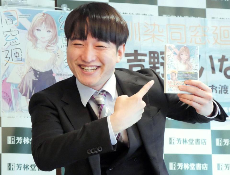 満面の笑みで著書をアピールする吉野おいなり君