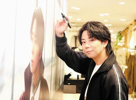 「ｎｅｗａｒｔ　ＧＩＮＺＡ【ＮＡＧ】」大阪ポップアップストアの店内特設ビジュアルにサインする北山宏光