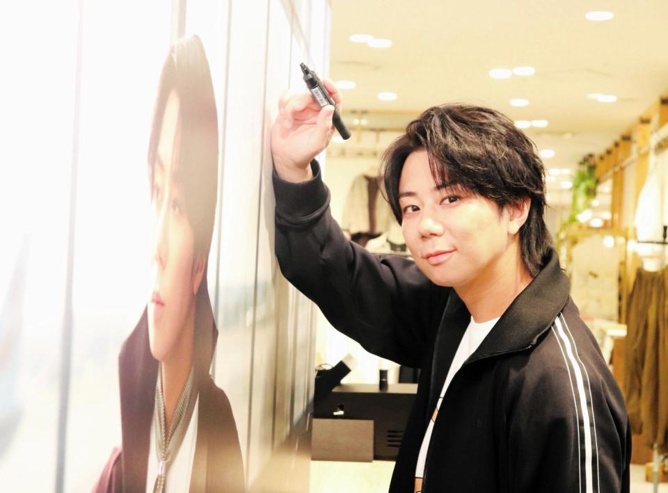 「ｎｅｗａｒｔ　ＧＩＮＺＡ【ＮＡＧ】」大阪ポップアップストアの店内特設ビジュアルにサインする北山宏光