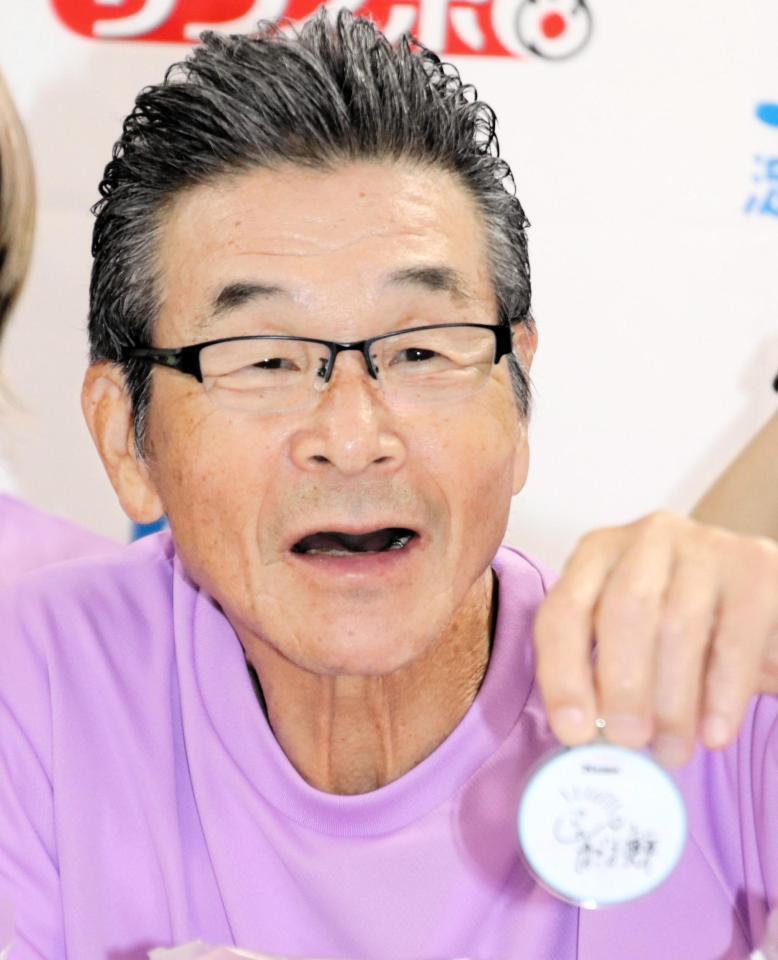 グッズに書いたサインを披露する間寛平