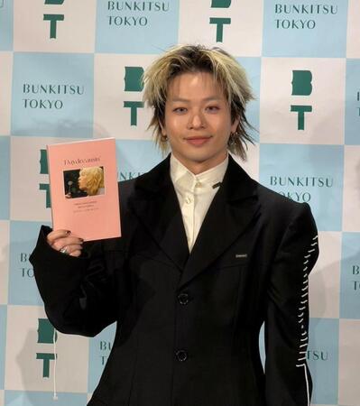 初の書籍を手に笑顔を浮かべる山本彰吾