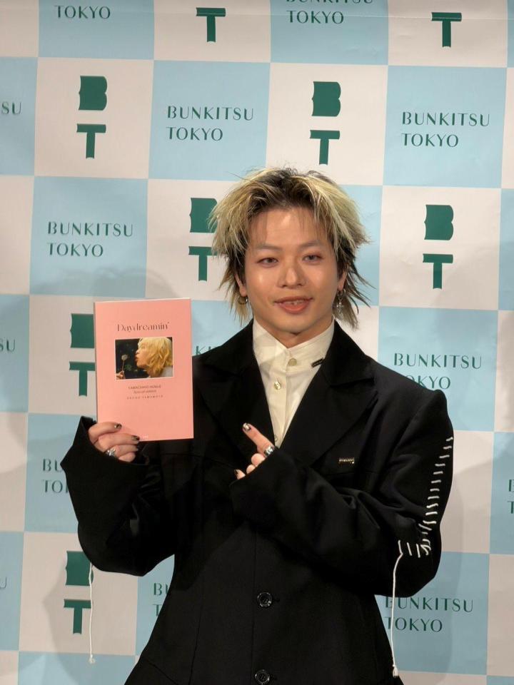 初の書籍を手に笑顔を浮かべる山本彰吾