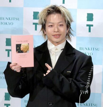 初の書籍を手に笑顔の山本彰吾