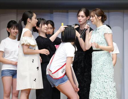 苦労しながら３人がかりで中島璃娃さん（中央）にティアラをつける平祐奈（左から２人目）、トラウデン直美（右から２人目）、新川優愛（右）＝撮影・西岡正