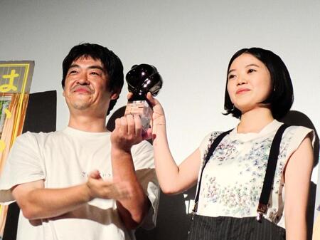 第３１回釜山国際映画祭の最優秀俳優賞トロフィーを見せる姫野花春（右）と沖田修一監督
