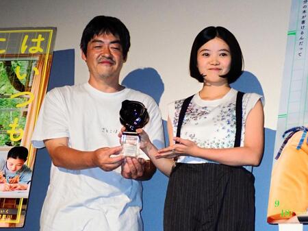 第３１回釜山国際映画祭の最優秀俳優賞トロフィーを見せる姫野花春（右）と沖田修一監督
