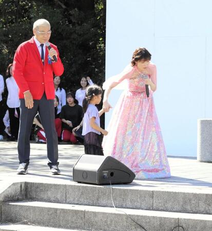 ステージに上がり込んだ迷子の手を引く水森かおり（右）と見守るオール巨人（左）