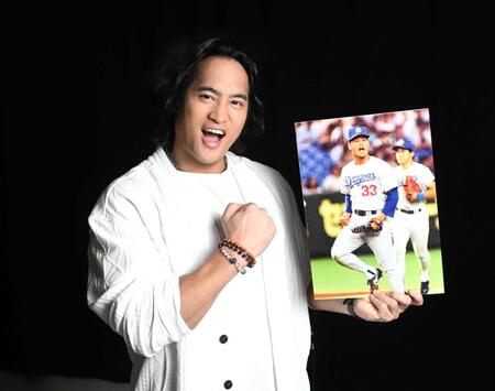 父・郭源治さんの写真を手にポーズをとる佳久創（撮影・堀内翔）