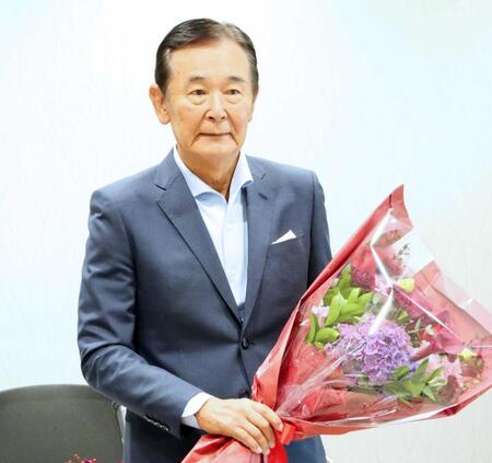 花束を手に会見する都倉俊一氏