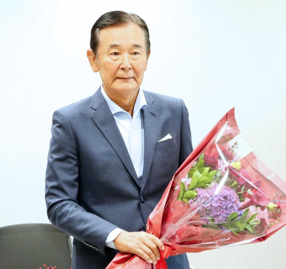 花束を手に会見する都倉俊一氏