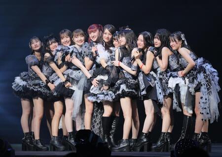 ステージ上で抱き合う秋山眞緒（左から５人目）ら、つばきファクトリー（撮影・吉澤敬太）