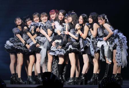 メンバーに抱きつかれ笑顔を見せる秋山眞緒（左から５人目）＝撮影・吉澤敬太