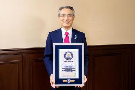 ギネス世界記録の認定証を手にする明治安田・永島英器社長