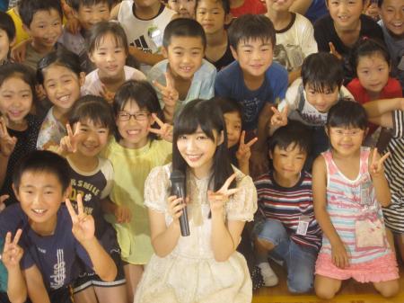 　子どもたちに囲まれ笑顔でＶサインを見せる指原莉乃＝大分市内