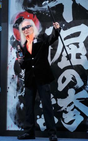 　「不倔の誇」と書かれた書画をバックにロックンロールポーズをとる内田裕也＝東京・新宿モア４番街