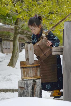 　本番前のテストで、くみ上げた井戸水をおけに移す浜田ここね＝山形県遊佐町