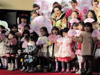 子供たちに囲まれ笑顔のデヴィ夫人（中央列左から３番目）＝都内