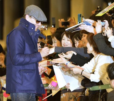 　来日し、笑顔で出迎えたファンにサインするレオナルド・ディカプリオ＝成田空港（撮影・吉澤敬太）