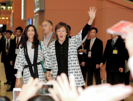 ポール・マッカートニーは、妻のナンシーさんと手をつなぎながらファンの声援に応える＝関西国際空港（撮影・田中太一）