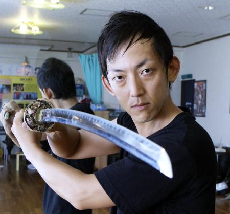 　刀を構え気合の入った表情を見せる笑撃武踊団の構成作家で脚本家、俳優の佐々木みつる＝大阪市のスタジオ天六（撮影・佐々木彰尚）
